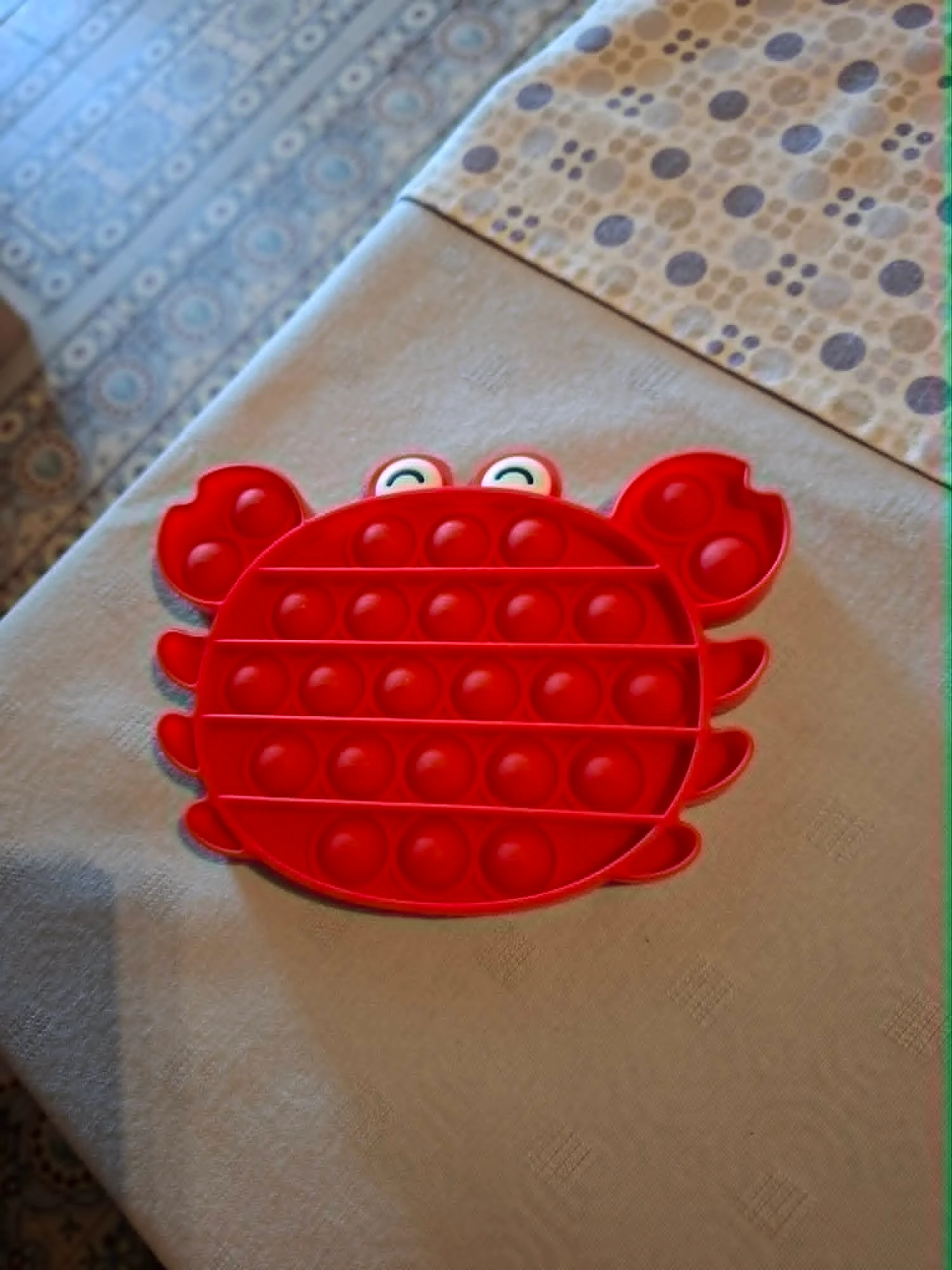Pop It fidget toy in de vorm van een rode krab